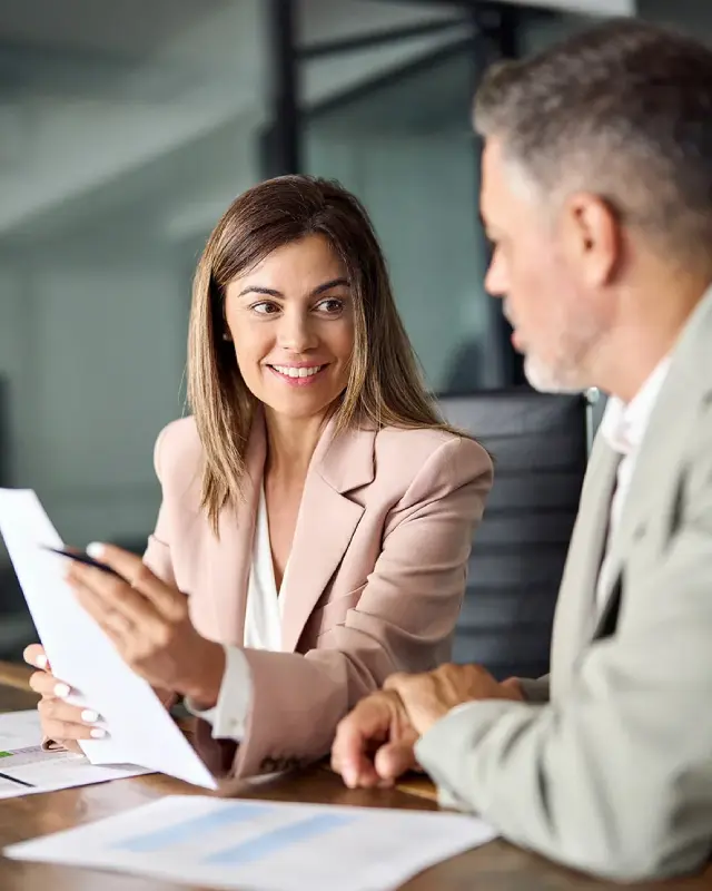Finanzberater in einem modernen Büro erklärt einer Kundin langfristige Finanzplanung