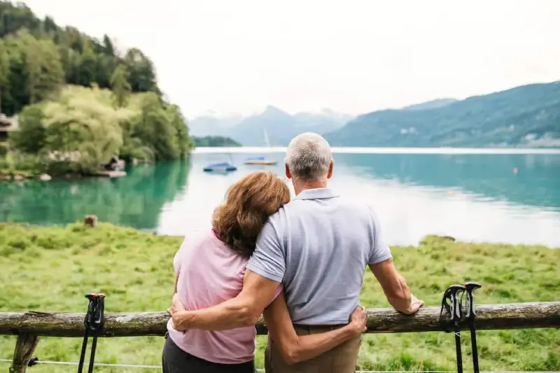 Glückliches älteres Paar an einem hellen See als Sinnbild für langfristige Ruhestandsplanung